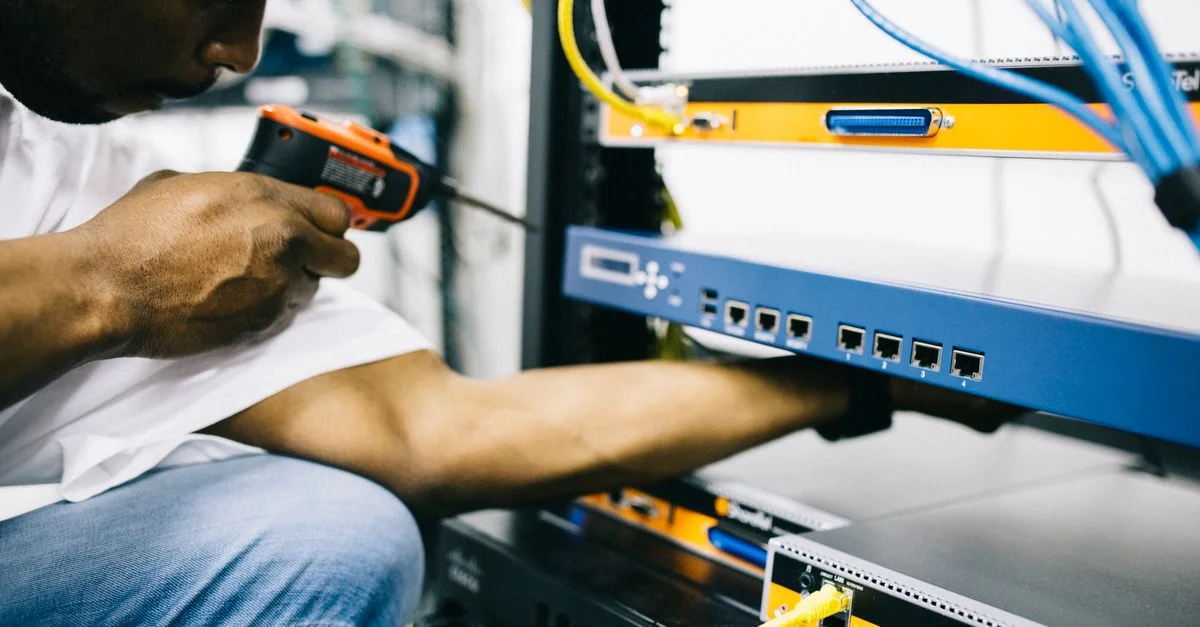 Technicien se concentrant sur la maintenance et la réparation de l'équipement dans un centre de données avec précision.